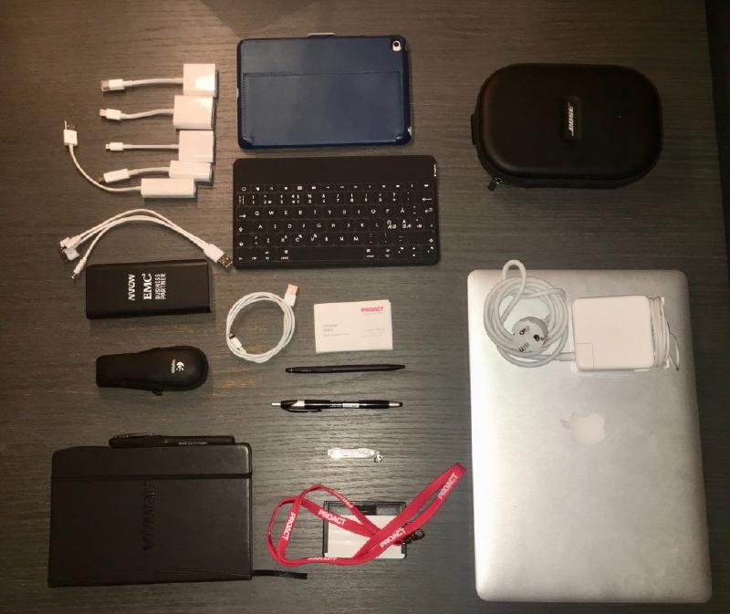 Everyday carry items laid out beside the bag, including a MacBook Pro, iPad Mini, keyboard, cables, pens and a Bose headset case